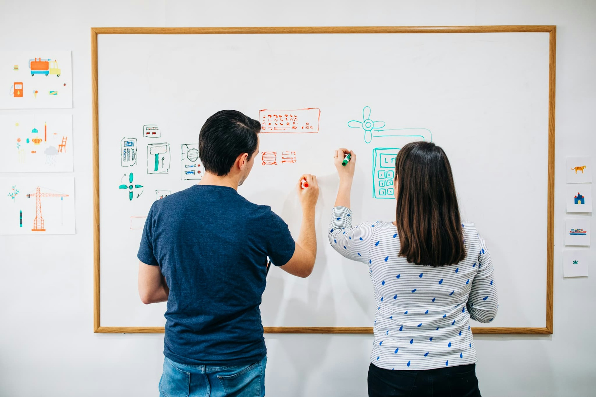 Esther and Mathijs, co-founders of Pok Pok, pictured working on a whiteboard in a design meeting.